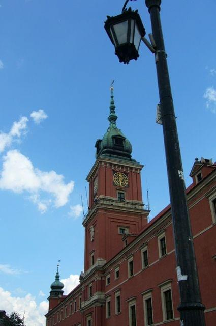 Latarnia, a w tle wieża z Zamku Królewskiego na Starym Mieście w Warszawie.